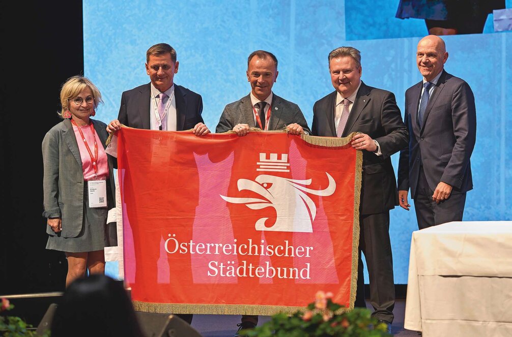 Im Rahmen der Vollversammlung wurde die Städtebund-Fahne feierlich an den Salzburger Bürgermeister Bernhard Auinger übergeben – der 76. Österreichische Städtetag geht im Mai 2027 in der Mozartstadt über die Bühne.